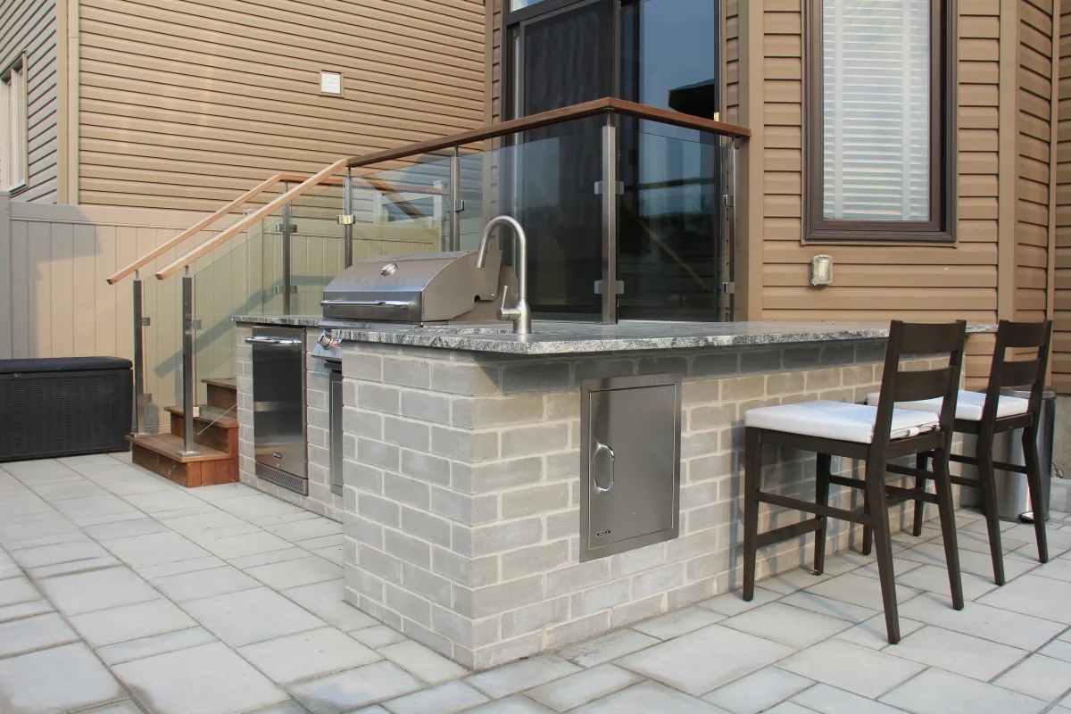 Mickelberry built-in grill island and glass-railed pool deck