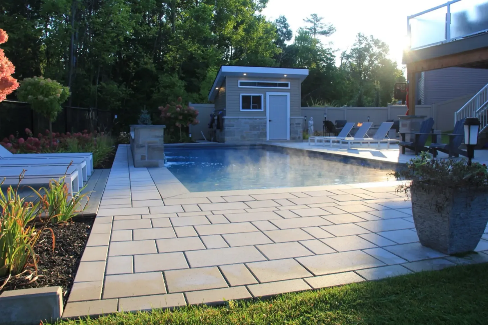 Astrolabe heated pool beside a modern pool house and large-format paving