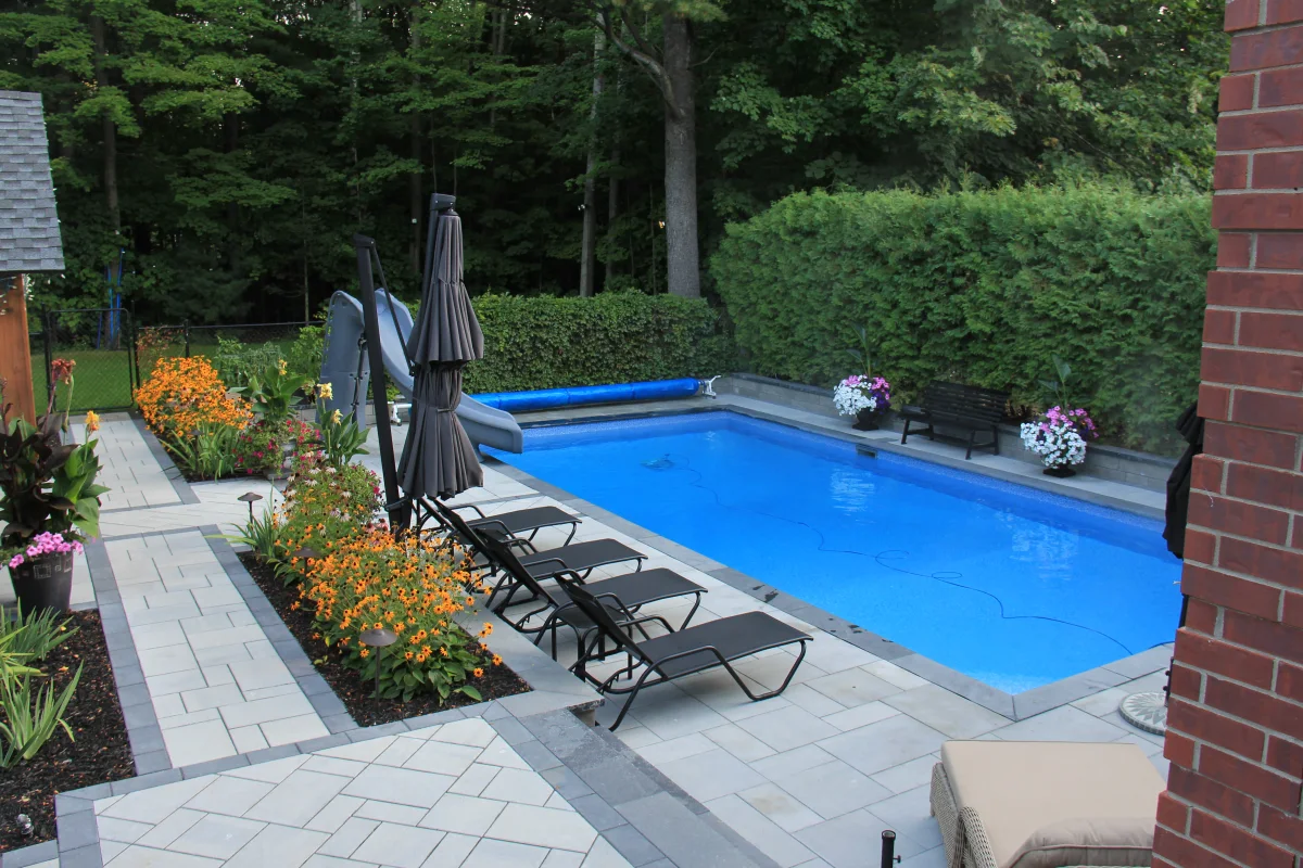 Rivercrest pool surrounded by interlock and flowering beds