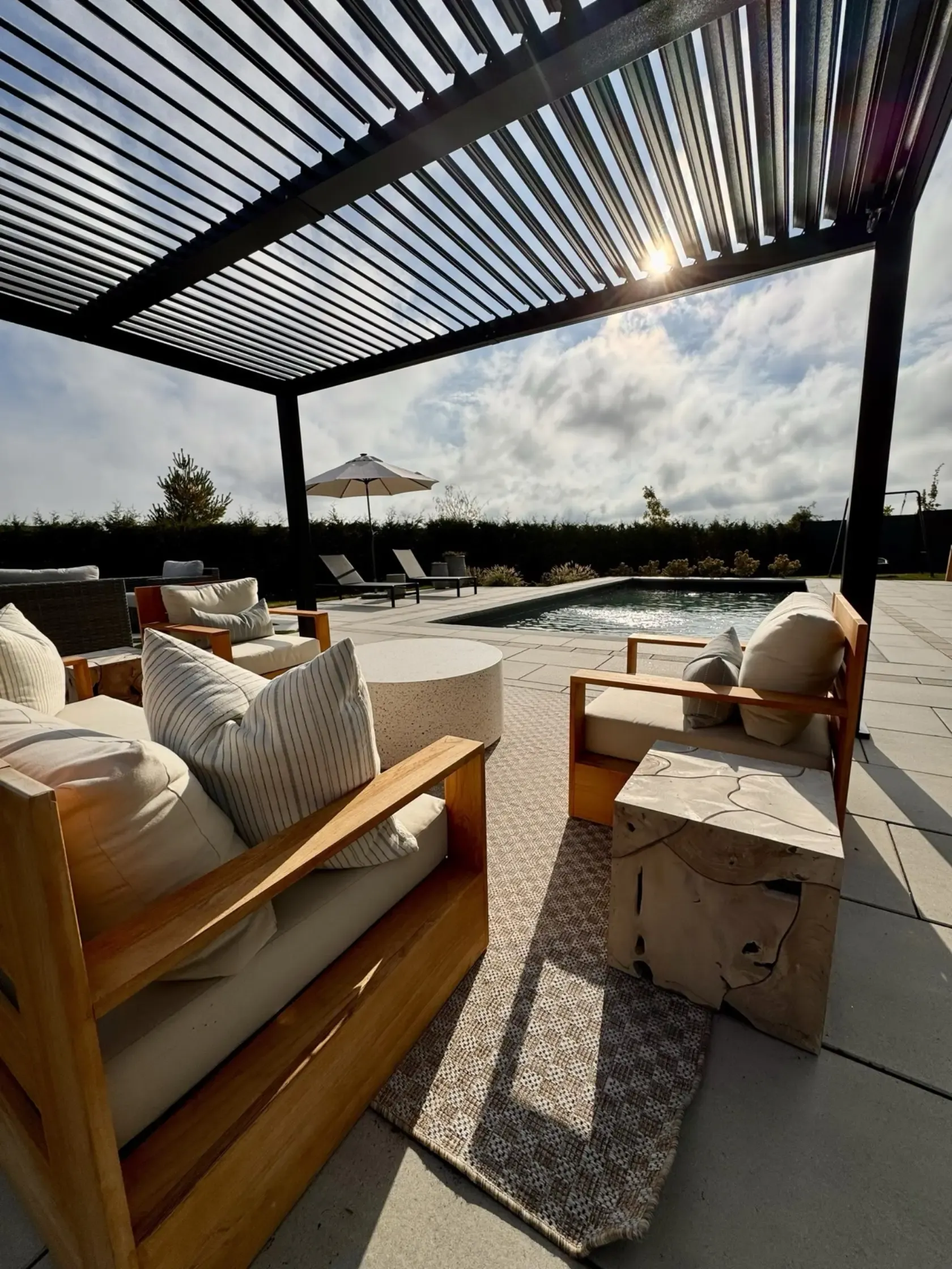Louvered pergola above a furnished outdoor room