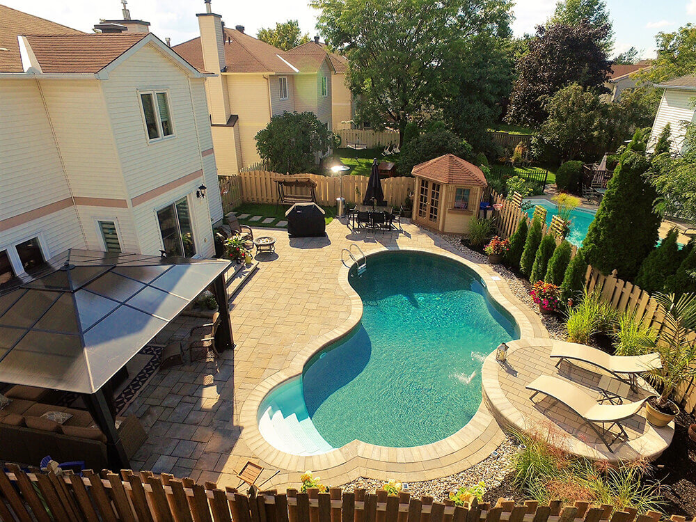 An aerial shot of a compact backyard pool and patio.