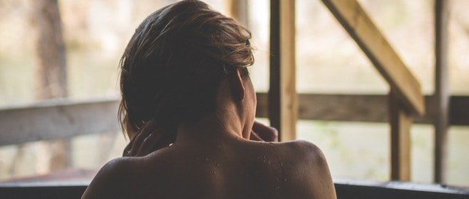 A woman looks out on her backyard from the comfort of a hot tub.