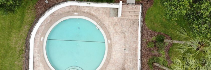 birds-eye view of circular inground pool with custom backyard landscaping