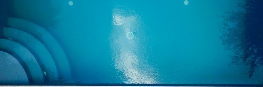 Woman sunbathes next to her inground swimming pool