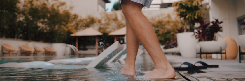 Man stepping into an inground pool