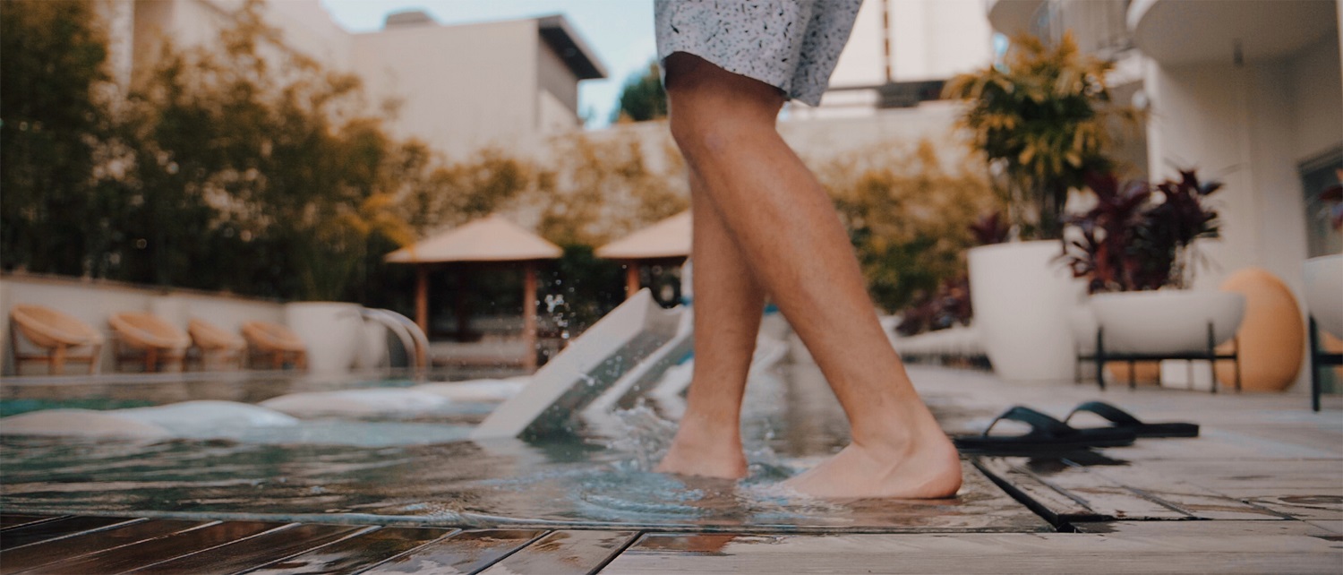 Man stepping into an inground pool