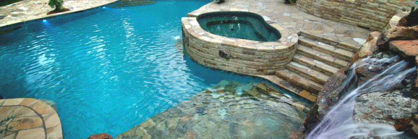 aerial view of luxury pool and spa in a unique shape with interlocking stone