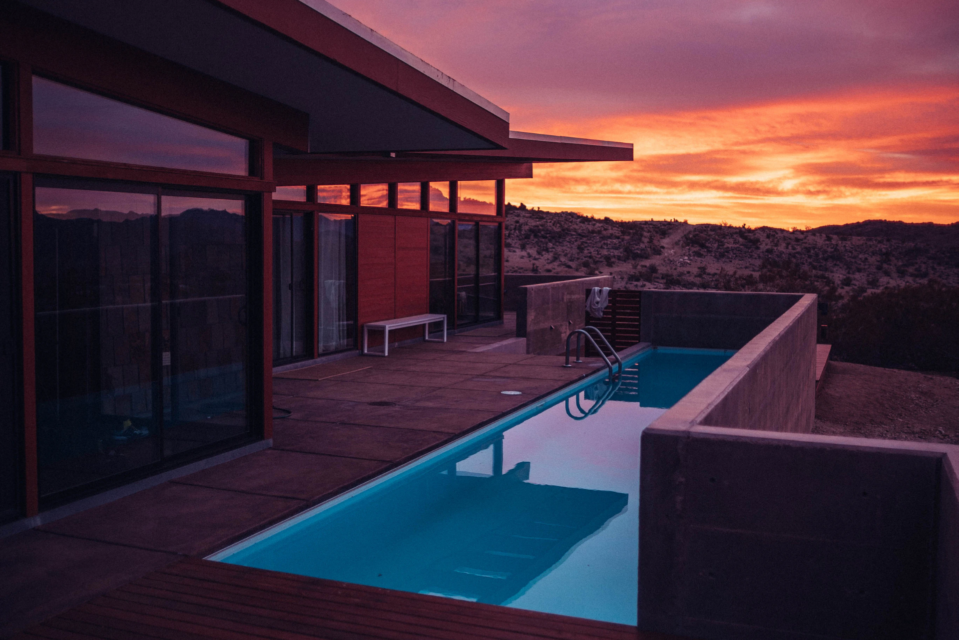 sunset view of backyard inground narrow swimming pool