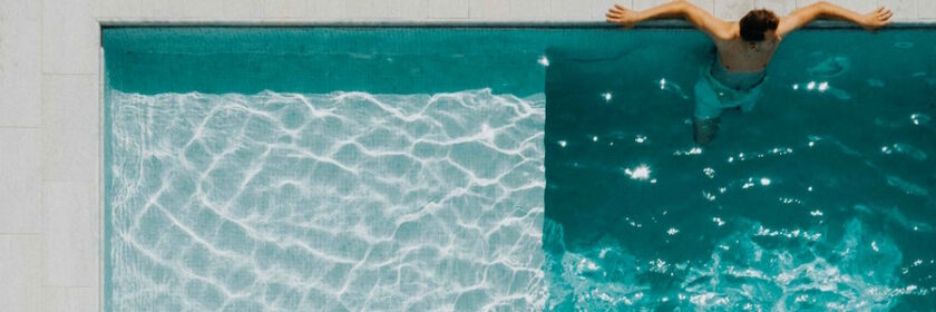 Man sitting at the end of a pool