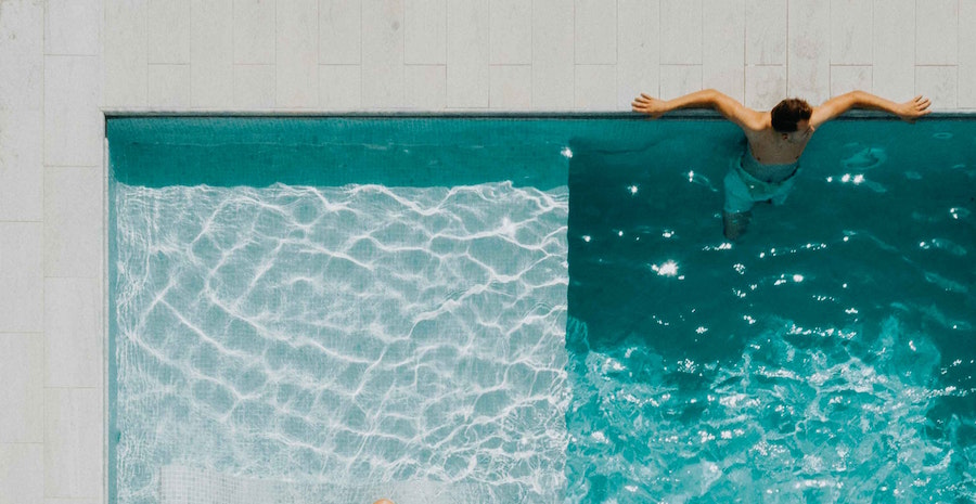 Man sitting at the end of a pool