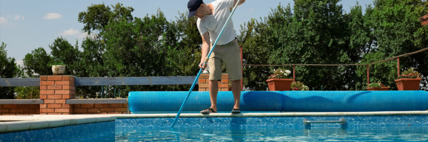 Men Cleaning his pool on a nice summer day