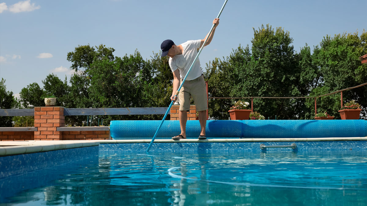 Men Cleaning his pool on a nice summer day